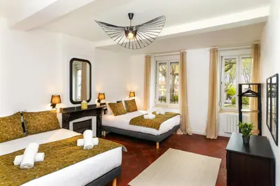a living room with two beds and a fireplace at L'art de Gambetta ConciergerieDameCarcas in Carcassonne