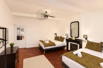 a hotel room with two beds and a mirror at L'art de Gambetta ConciergerieDameCarcas in Carcassonne