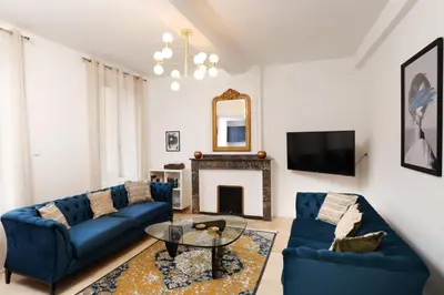 a living room with blue couches and a fireplace at L'art de Gambetta ConciergerieDameCarcas in Carcassonne