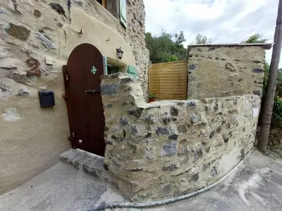 a stone building with a door and a stone wall at Le Cantou de Juliette (studio) in Prugnanes
