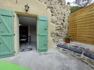 an open door to a stone building with green doors at Le Cantou de Juliette (studio) in Prugnanes
