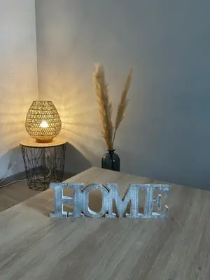 a home sign on a table next to a lamp at NATURE by Reine du Sud, proche des Grands Buffets in Narbonne