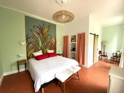 a bedroom with a large bed with a painting on the wall at Domaine de Lanis - Chambres d'hôtes avec parc et piscine in Castelnaudary