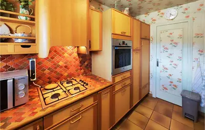 a kitchen with wooden cabinets and a stove top oven at 2 Bedroom Cozy Home In Cébazan in Cébazan