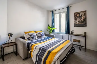 a bedroom with a bed and a window at L'appart cinéma Centre ville Narbonne in Narbonne
