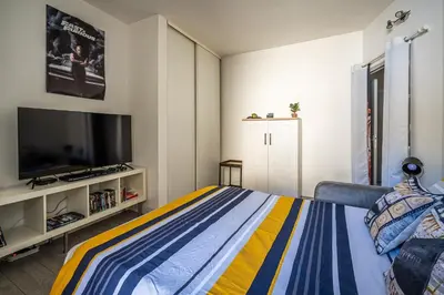 a bedroom with a bed and a flat screen tv at L'appart cinéma Centre ville Narbonne in Narbonne