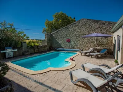 a swimming pool with two chairs and an umbrella at Lécurie in Montréal