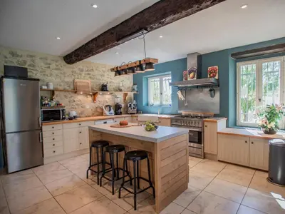 a kitchen with a refrigerator and a counter with stools at Lécurie in Montréal