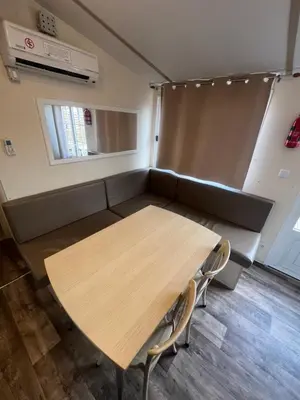a meeting room with a table and a couch at Les mobil homes de NOLY TV CLIM 6places in Port-la-Nouvelle