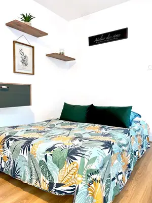 a bedroom with a bed with a colorful blanket at Superbe Appt avec cour et parking gratuit à 5min de la cité médiévale in Carcassonne
