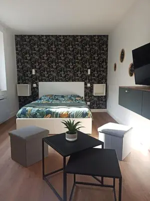 a bedroom with a bed and a table and a table sidx sidx sidx at Superbe Appt avec cour et parking gratuit à 5min de la cité médiévale in Carcassonne