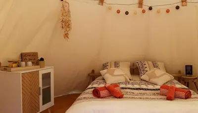 a bedroom with a bed with pillows on it at Le tipi à Marie, déconnectez- vous !!! in Cambounès