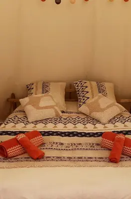 a bed with two pillows on top of it at Le tipi à Marie, déconnectez- vous !!! in Cambounès