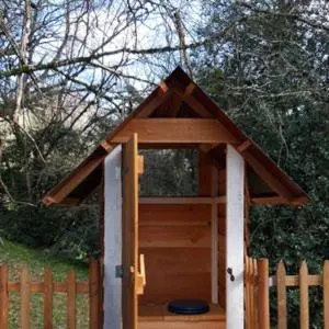 a wooden dog house with a roof on a fence at Le tipi à Marie, déconnectez- vous !!! in Cambounès