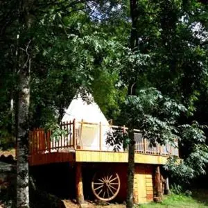 a tree house with a porch and a deck at Le tipi à Marie, déconnectez- vous !!! in Cambounès