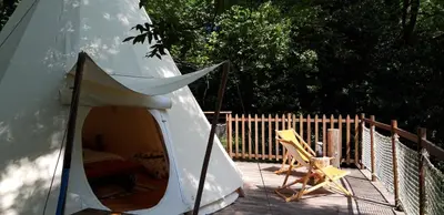 a white tent and a chair on a deck at Le tipi à Marie, déconnectez- vous !!! in Cambounès