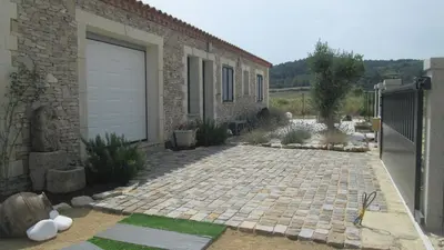 a brick house with a garage and a driveway at Villa Félines in Félines-Minervois