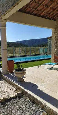a patio with a plant in a vase in front of a pool at Villa Félines in Félines-Minervois