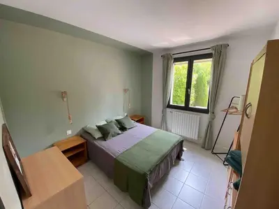 a bedroom with a bed and a large window at Maison de famille (piscine, jacuzzi et sauna) in Quillan