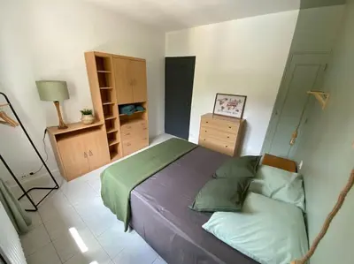 a bedroom with a bed with green sheets and a dresser at Maison de famille (piscine, jacuzzi et sauna) in Quillan