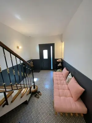 a living room with a pink couch and a staircase at Maison de famille (piscine, jacuzzi et sauna) in Quillan