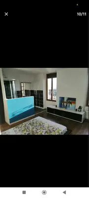 a large room with a blue bed and a rug at Charmant T2 refait à neuf, au cœur de Puylaurens in Puylaurens