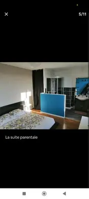 a living room with a bed and a blue table at Charmant T2 refait à neuf, au cœur de Puylaurens in Puylaurens
