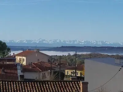 a view of a town with mountains in the background at Charmant T2 refait à neuf, au cœur de Puylaurens in Puylaurens