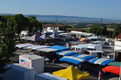 an aerial view of a parking lot with blue and white tents at Charmant T2 refait à neuf, au cœur de Puylaurens in Puylaurens