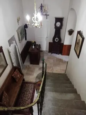 a room with a staircase and a grandfather clock at La Maison du Magistrat in Durban-Corbières