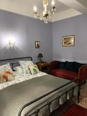 a bedroom with a bed and a red couch at La Maison du Magistrat in Durban-Corbières
