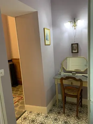 a room with a table and a chair and a mirror at La Maison du Magistrat in Durban-Corbières