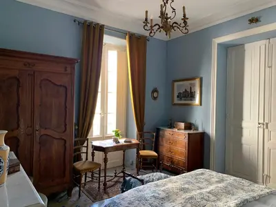 a bedroom with a bed and a desk and a table at La Maison du Magistrat in Durban-Corbières