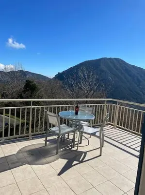 a table and two chairs on a balcony with mountains at Salvezines Villa in Salvezines