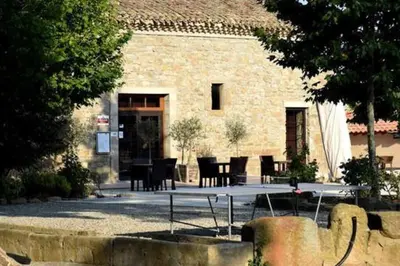 a table and chairs in front of a building at Le soleil d Eugènie appartement dans résidence avec Piscine commune près de Carcassonne in Olonzac