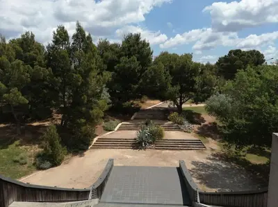 a group of stairs in a park with trees at Le soleil d Eugènie appartement dans résidence avec Piscine commune près de Carcassonne in Olonzac