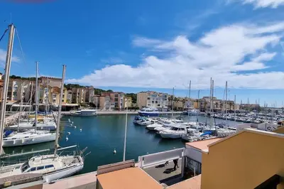 a group of boats docked in a harbor with buildings at Magnifique Studio sur le Port de Gruissan (2 à 4 pers) in Gruissan