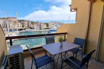 a balcony with a table and chairs and a view of a harbor at Magnifique Studio sur le Port de Gruissan (2 à 4 pers) in Gruissan