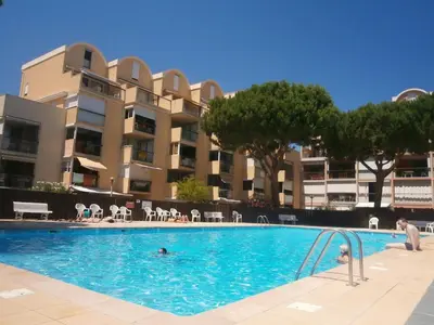 a swimming pool in front of a apartment building at Magnifique Studio sur le Port de Gruissan (2 à 4 pers) in Gruissan
