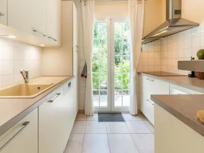 a kitchen with white cabinets and a large window at Charming Villa Stay Near Limoux in Limoux