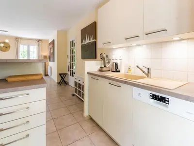 a large kitchen with white cabinets and a sink at Charming Villa Stay Near Limoux in Limoux