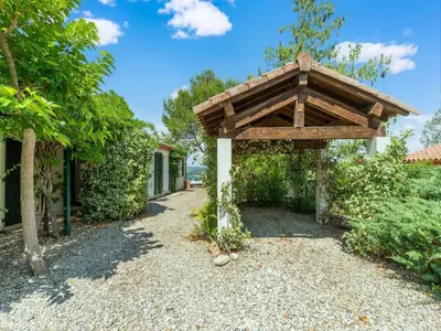 a garden with a wooden pergola next to a house at Charming Villa Stay Near Limoux in Limoux