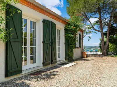 a house with green shutters and a window at Charming Villa Stay Near Limoux in Limoux