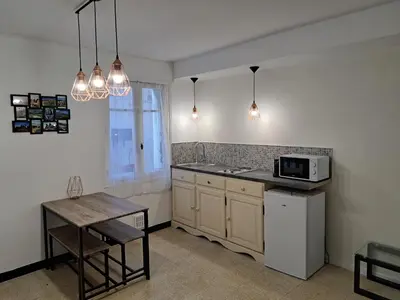 a kitchen with a sink and a microwave and a table at Bel appartement 2/4personnes in Douzens
