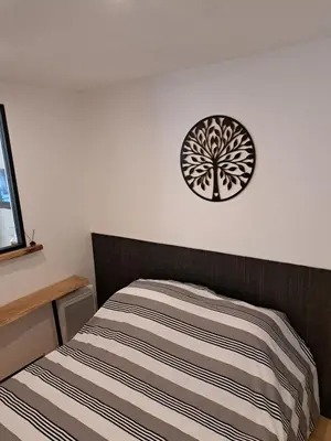 a bedroom with a bed and a clock on the wall at Bel appartement 2/4personnes in Douzens