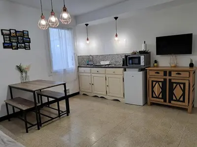 a kitchen with a small table and a microwave at Bel appartement 2/4personnes in Douzens