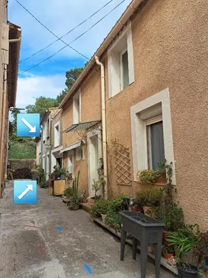 a house with two arrows on the side of it at Bel appartement 2/4personnes in Douzens