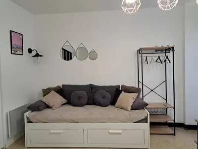 a living room with a couch and mirrors on the wall at Bel appartement 2/4personnes in Douzens