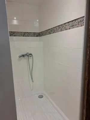 a white shower with a hose in a bathroom at Bel appartement 2/4personnes in Douzens