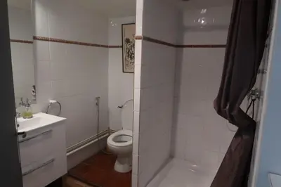 a white bathroom with a toilet and a sink at Gîte de l'arbre perché à Langel in Armissan